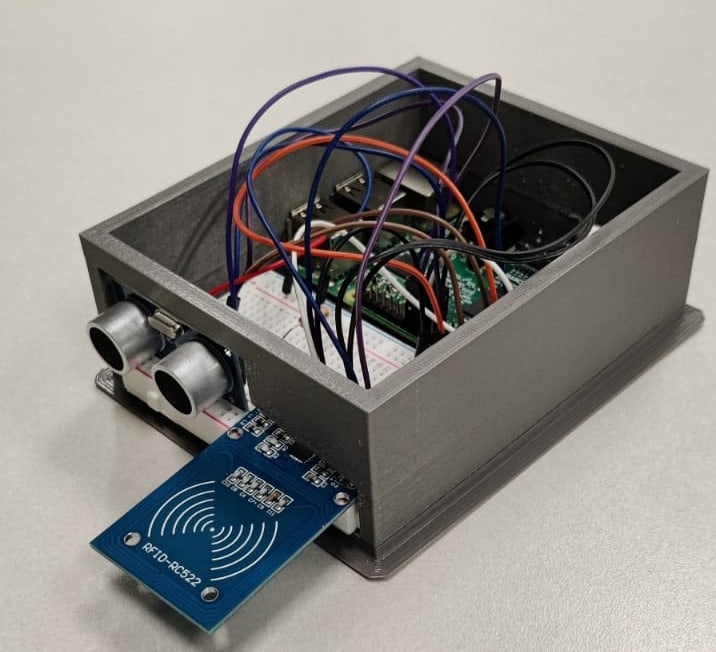 The Booth Beacon prototype: a 3D-printed enclosure holding a Raspberry Pi and breadboard, with an ultrasonic range finder and an RFID-RC522 reader on the front
