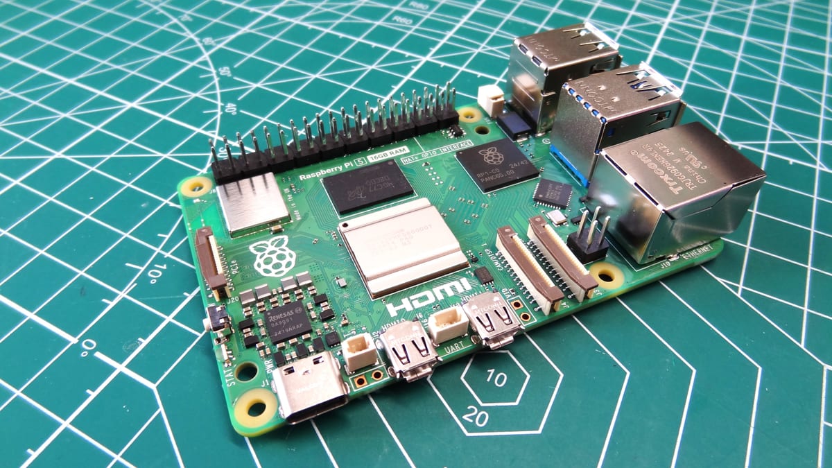 A Raspberry Pi 5 single-board computer on a cutting mat, showing the Broadcom BCM2712 SoC, the LPDDR4X package, the 40-pin header and the PCIe connector